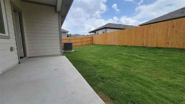 a view of backyard with tub and wooden fence