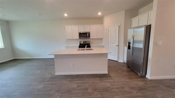 a kitchen with sink a microwave and cabinets