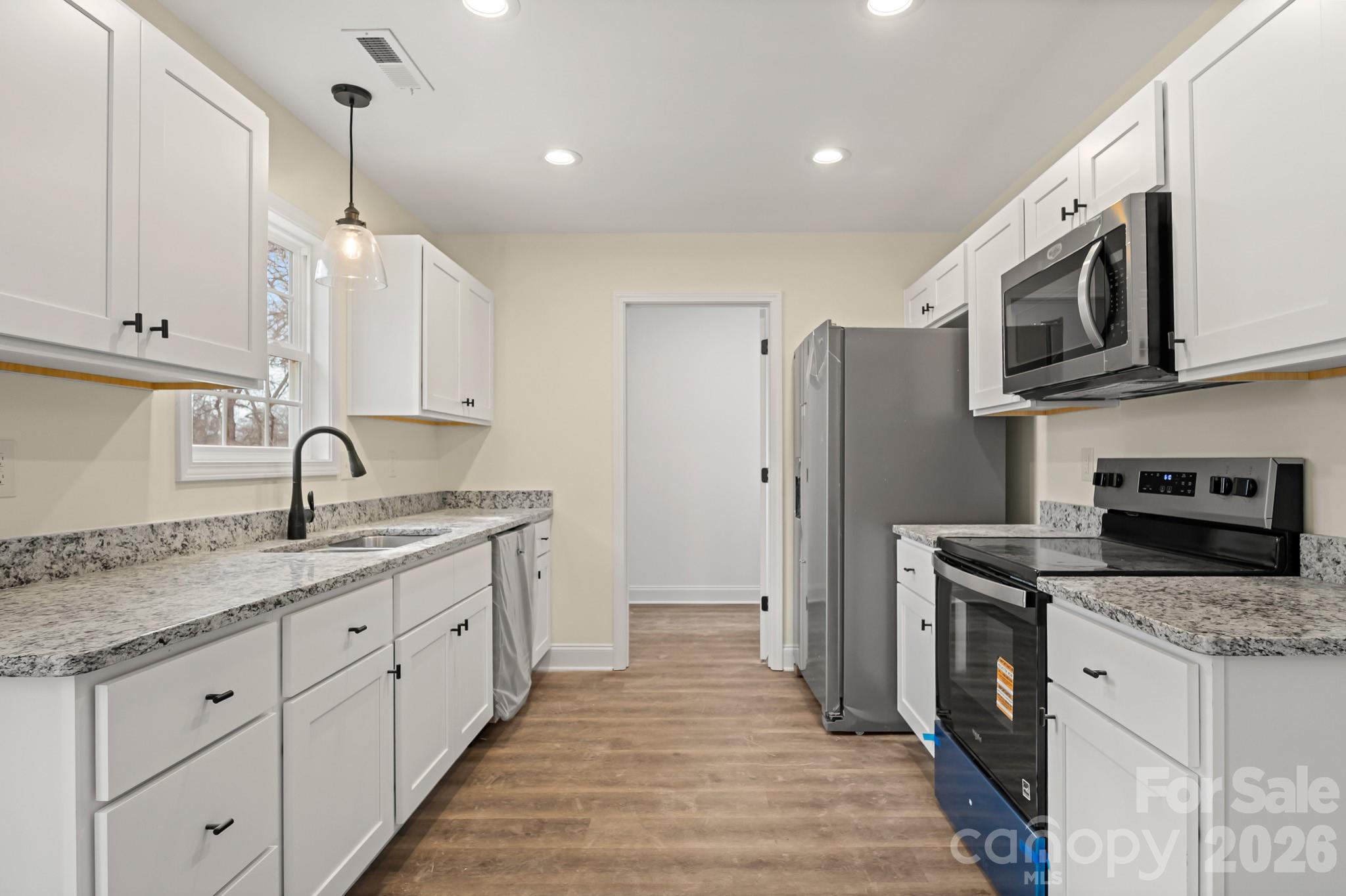 545 Washington Street Rock Hill, SC 29730 - Photo 9 of 29 a kitchen with stainless steel appliances granite countertop a sink and a stove