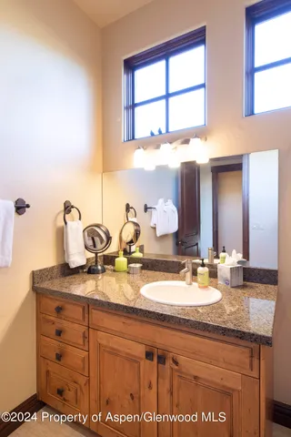 a bathroom with a granite countertop sink and a mirror
