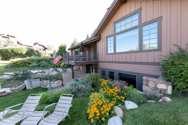 a front view of a house with a yard and potted plants