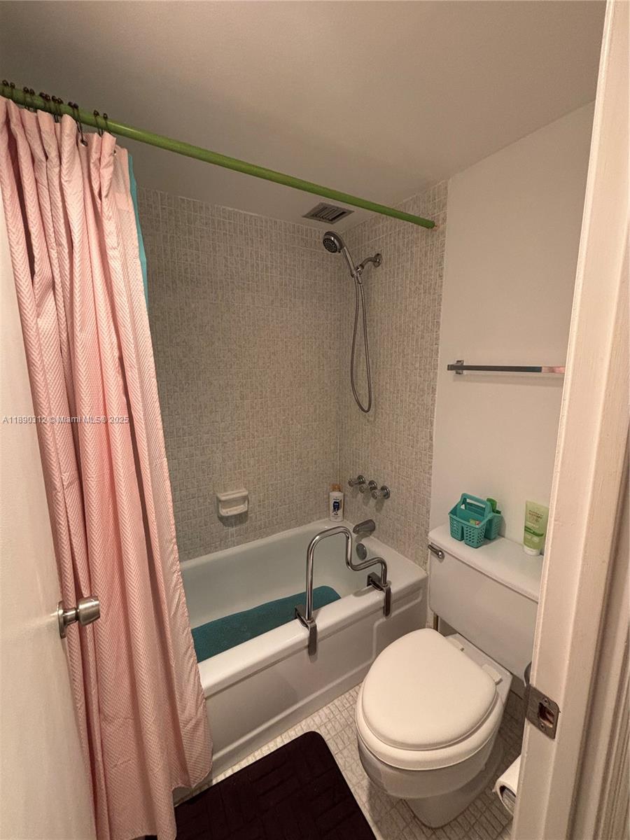 6901 Environ Boulevard, Unit 3F Lauderhill, FL 33319 - Photo 11 of 16 a bathroom with a sink a toilet a mirror and shower