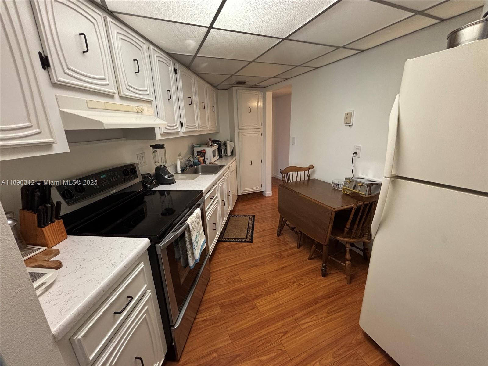 6901 Environ Boulevard, Unit 3F Lauderhill, FL 33319 - Photo 5 of 16 a kitchen with a sink appliances and cabinets