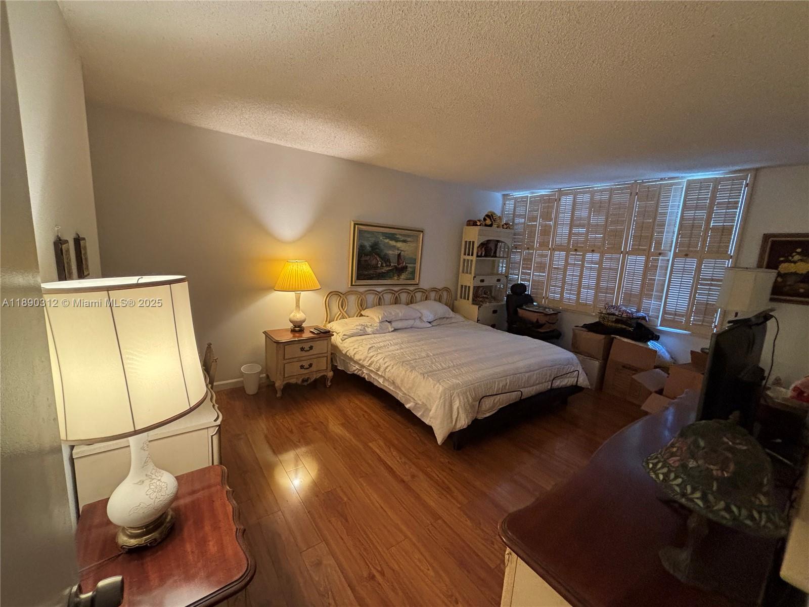 6901 Environ Boulevard, Unit 3F Lauderhill, FL 33319 - Photo 9 of 16 a bedroom with a bed and wooden floor