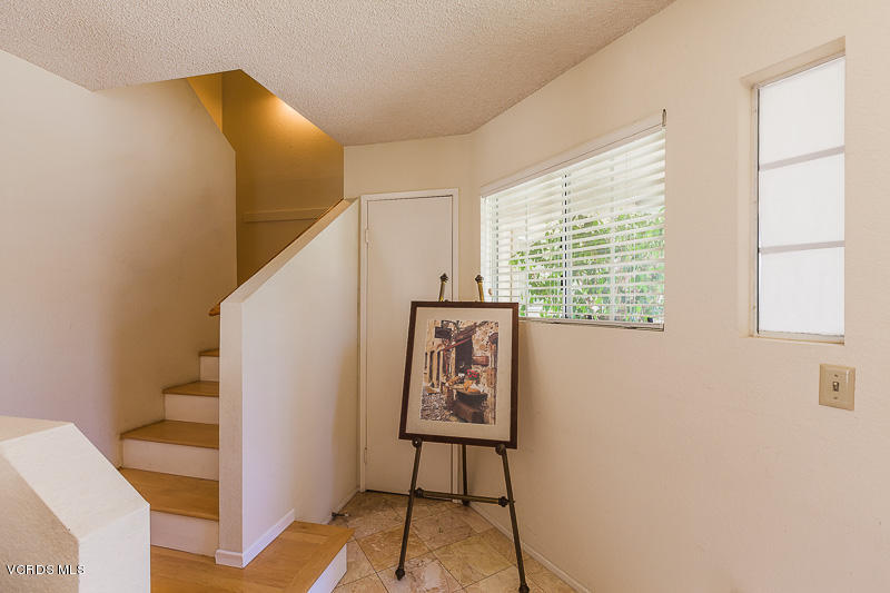 1225 Fitzgerald Road, Unit B Simi Valley, CA 93065 - Photo 4 of 34 a view of a hallway with paintings on the wall