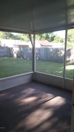 a view of a backyard with tree and wooden fence