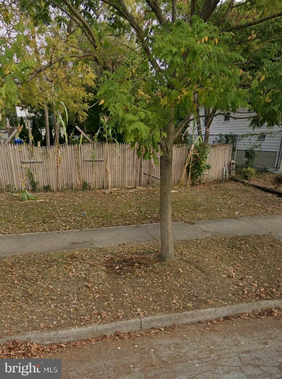 a view of a yard with wooden fence