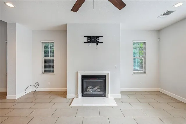 an empty room with windows and fireplace