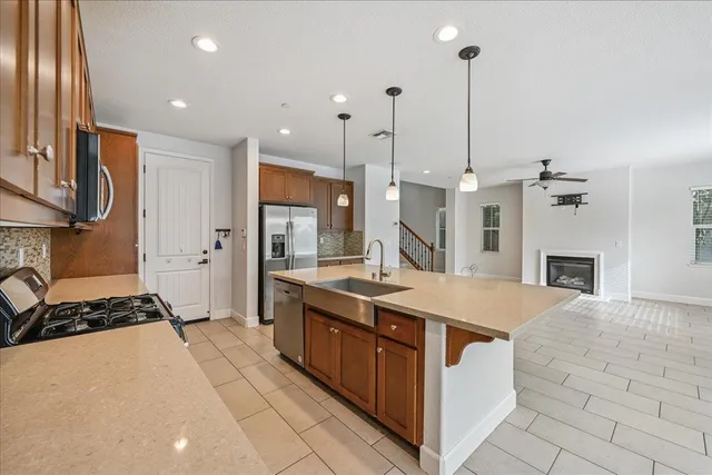 a open kitchen with stainless steel appliances granite countertop a stove a sink and a refrigerator