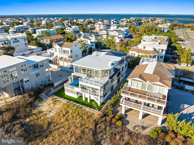 an aerial view of ocean and residential houses with outdoor space