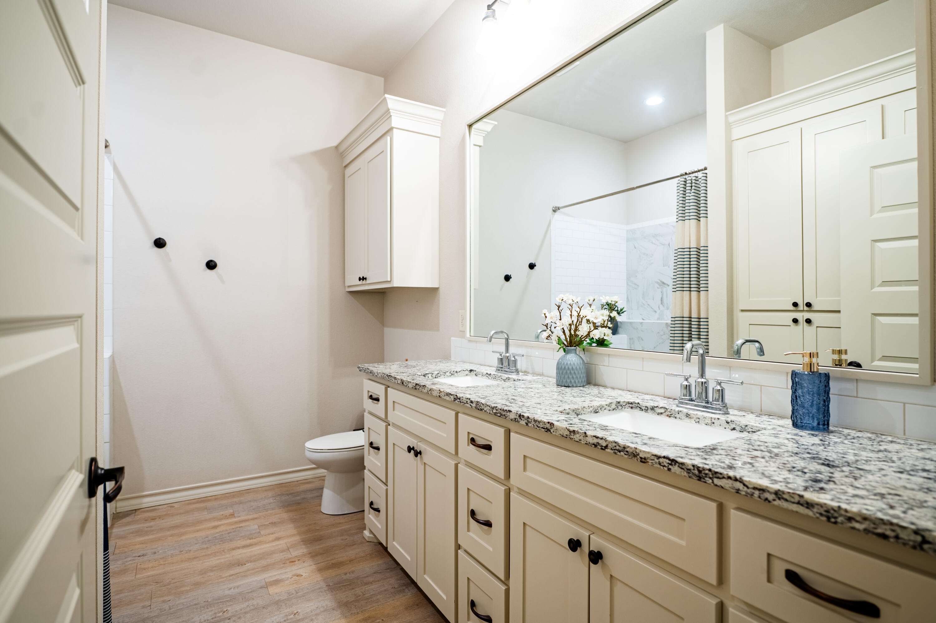 3442 126th Street Lubbock, TX 79423 - Photo 26 of 53 a bathroom with a granite countertop sink a toilet and a mirror