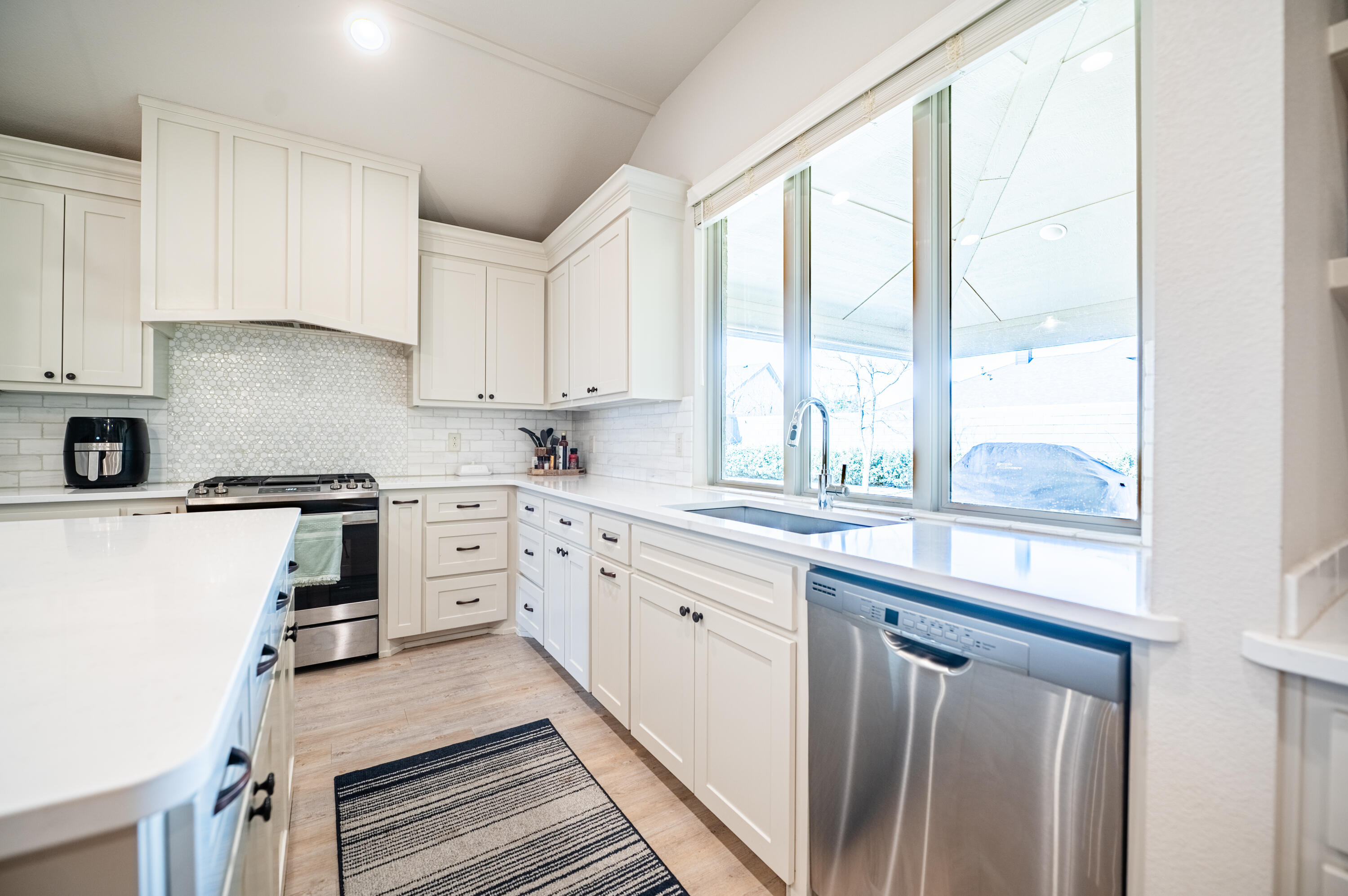 3442 126th Street Lubbock, TX 79423 - Photo 34 of 53 a kitchen with granite countertop white cabinets and white appliances
