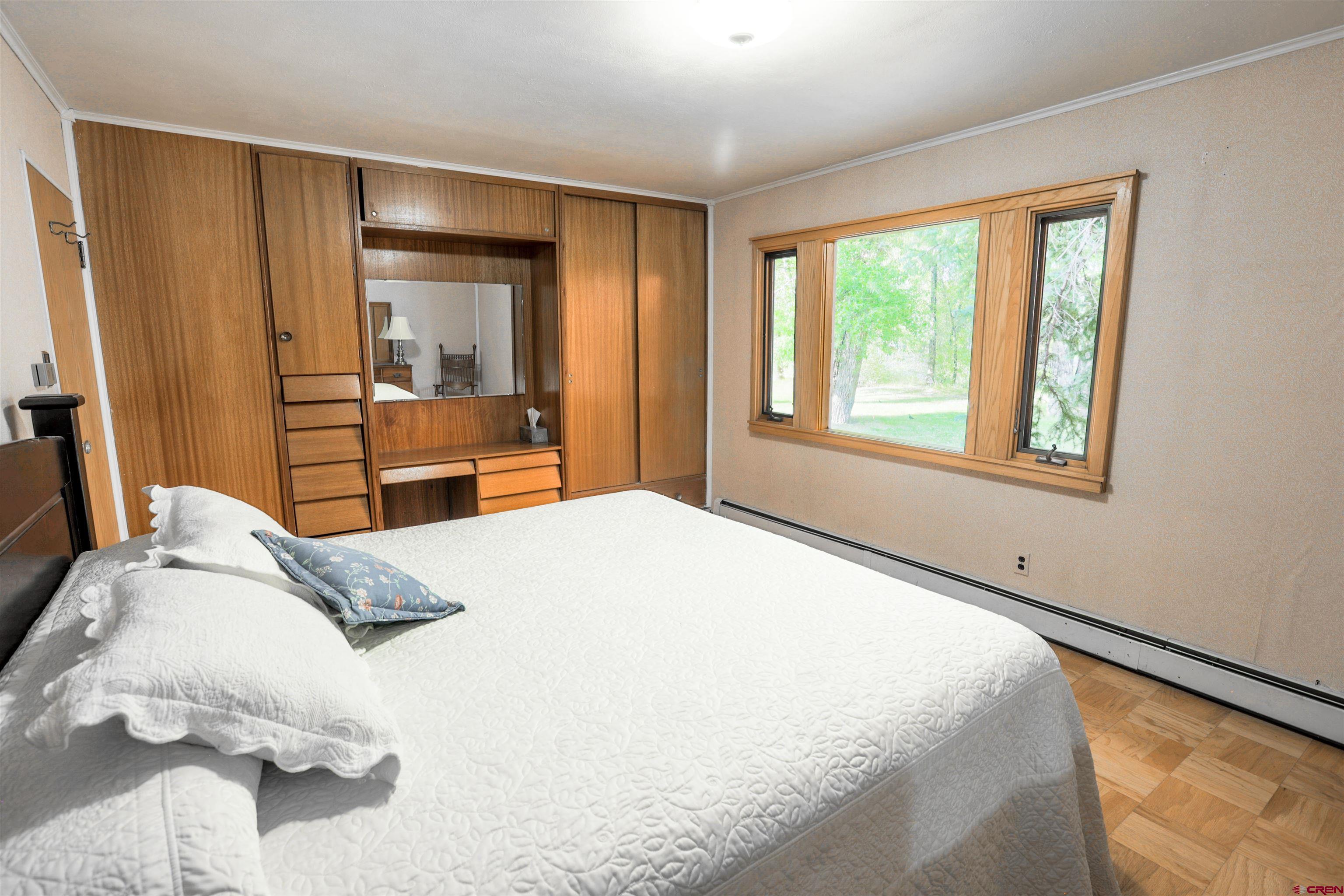 128 Bevington Road Gunnison, CO 81230 - Photo 11 of 37 a bedroom with a large bed and a large window