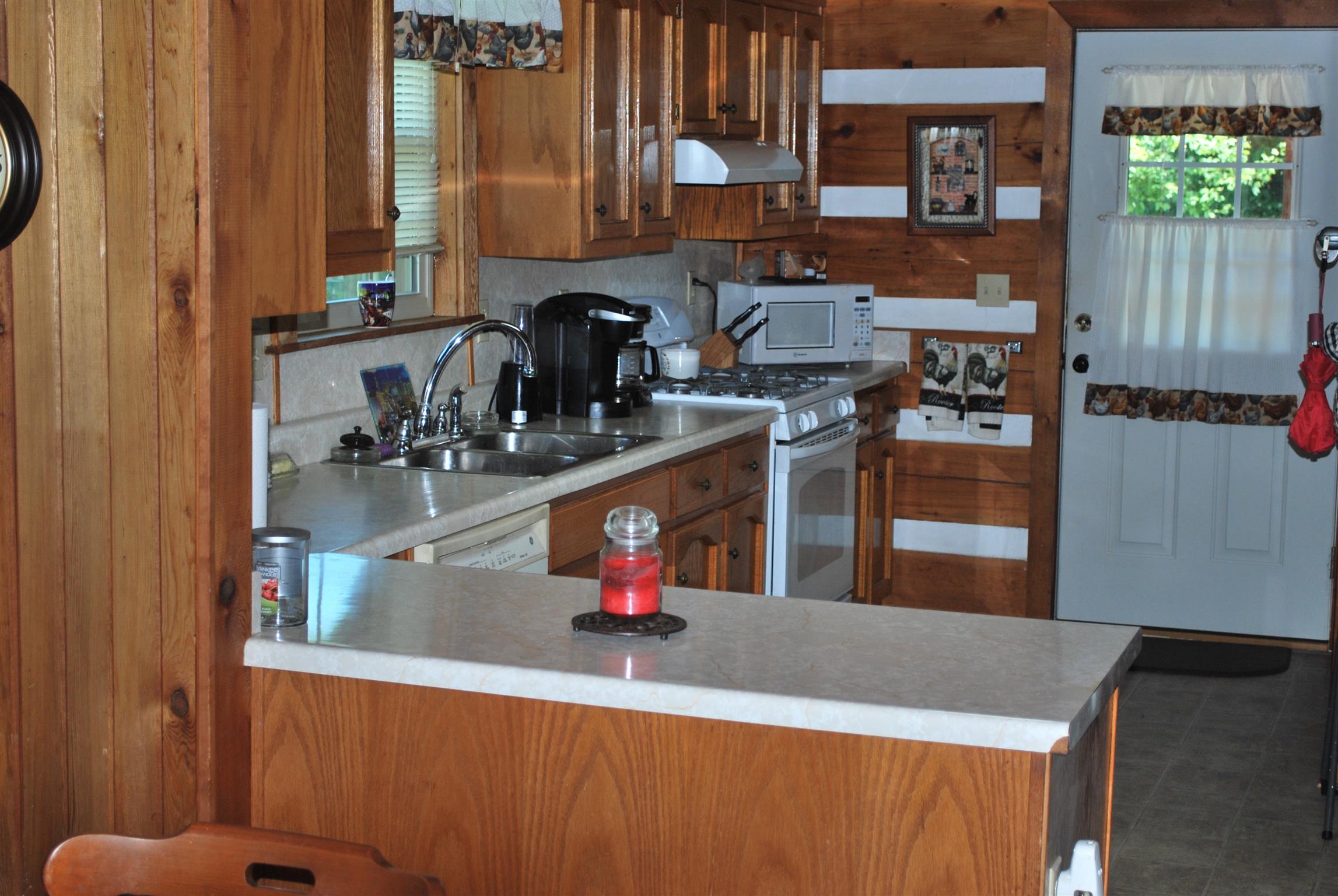 5729 Keysburg Road Adams, TN 37010 - Photo 17 of 30 a kitchen with kitchen island granite countertop a sink cabinets and window