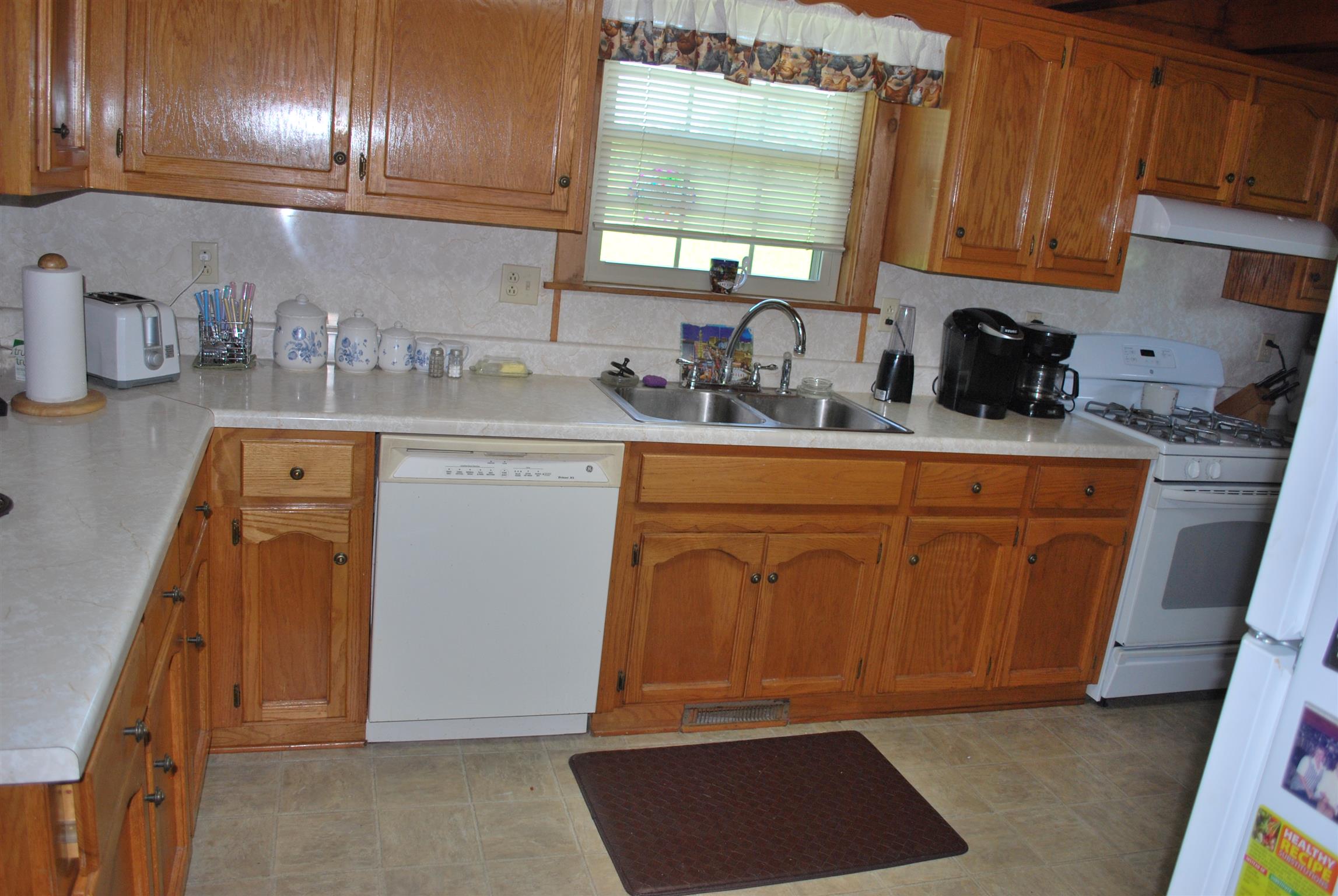 5729 Keysburg Road Adams, TN 37010 - Photo 19 of 30 a kitchen with stainless steel appliances granite countertop a sink dishwasher stove and cabinets