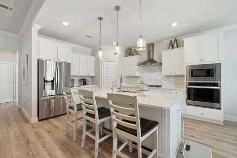 a kitchen with kitchen island a stove and a sink