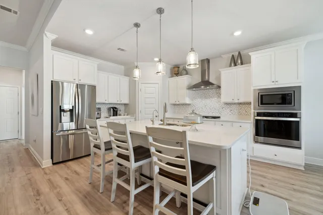 a kitchen with kitchen island a stove and a sink