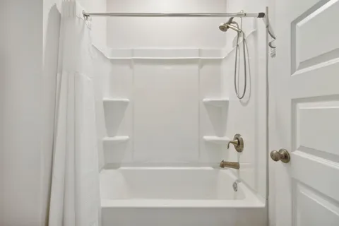 a bedroom with a bed wooden floor and window