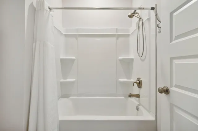 a bedroom with a bed wooden floor and window