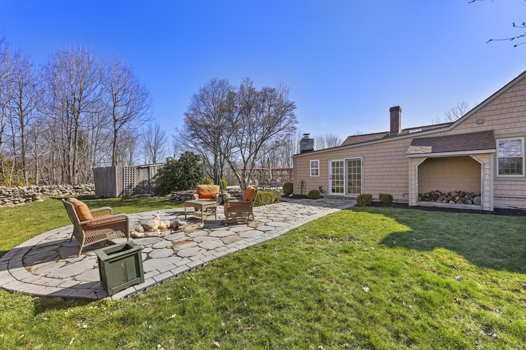71 Prindle Hill Road Charlton, MA 01507 - Photo 34 of 40 a view of a backyard with table and chairs potted plants and a palm tree