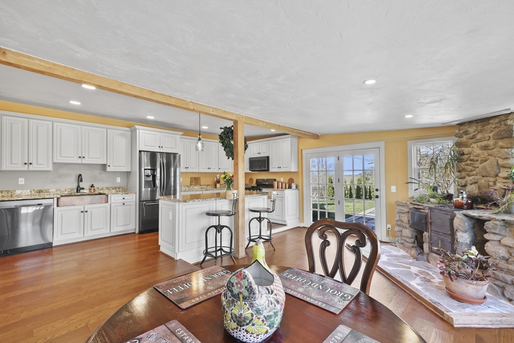 71 Prindle Hill Road Charlton, MA 01507 - Photo 10 of 40 a kitchen with stainless steel appliances granite countertop a refrigerator a stove top oven a sink dishwasher and white cabinets with wooden floor