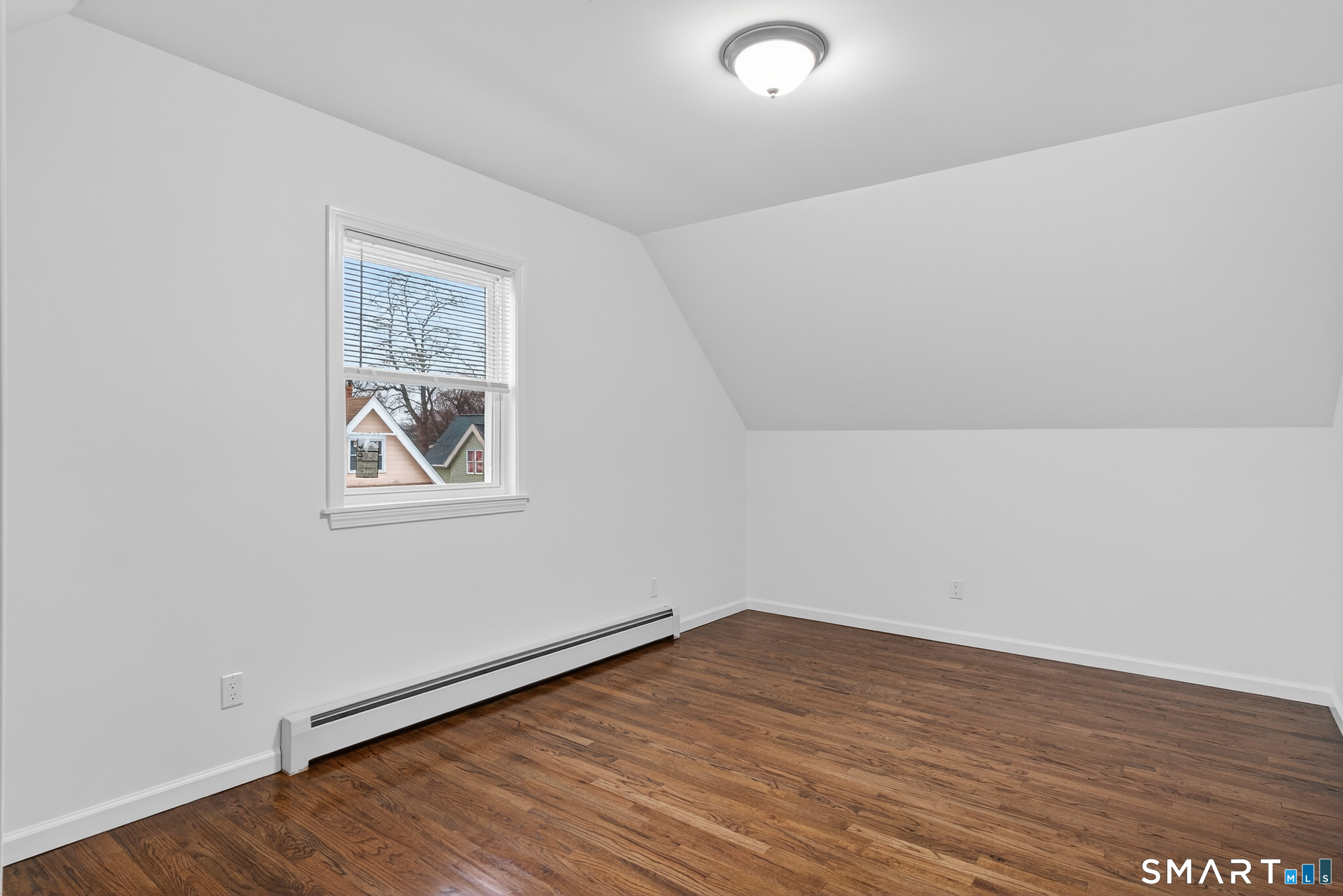 144 Cottage Street, Unit 3 Bridgeport, CT 06605 - Photo 2 of 12 an empty room with wooden floor and windows
