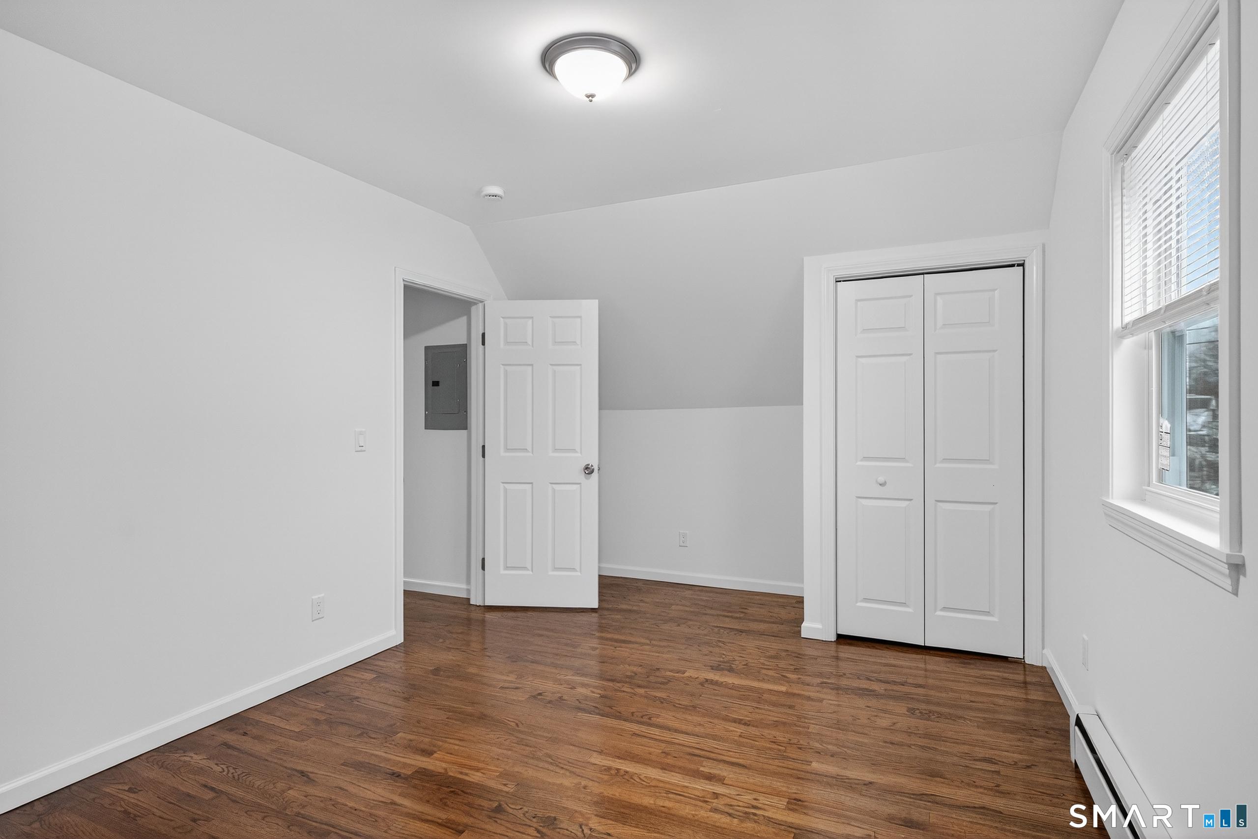 144 Cottage Street, Unit 3 Bridgeport, CT 06605 - Photo 3 of 12 an empty room with wooden floor and windows