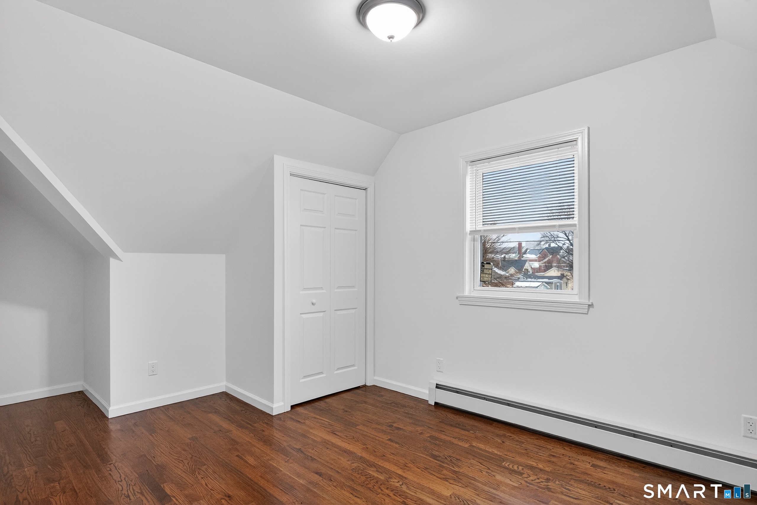 144 Cottage Street, Unit 3 Bridgeport, CT 06605 - Photo 5 of 12 an empty room with wooden floor and windows