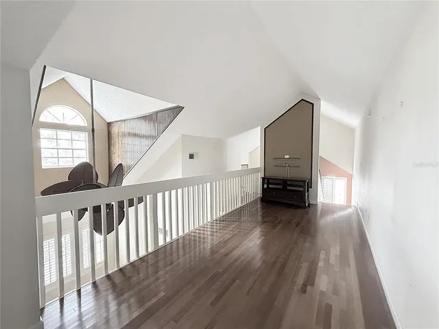 a view of a hallway with wooden floor and entryway