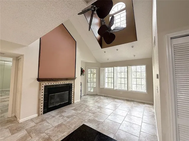 an empty room with windows and fireplace