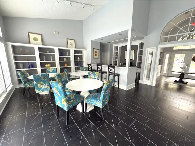 a view of a dining room with furniture a potted plant and wooden floor