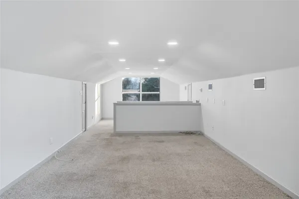 a view of an empty room with a kitchen