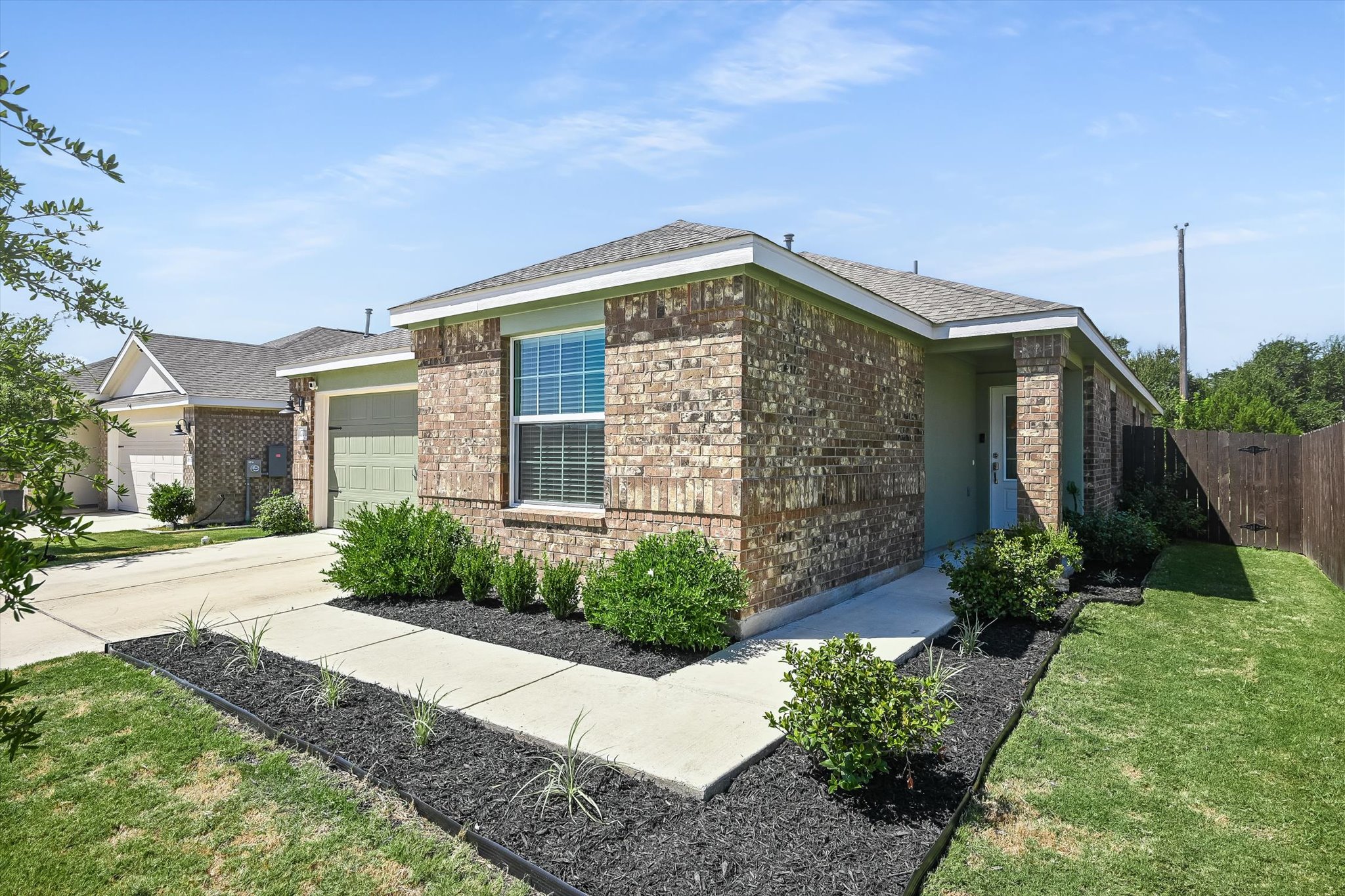 1701 Chapel Ranch Road Georgetown, TX 78628 - Photo 1 of 28 Manicured landscaping borders the concrete walkway leading to a charming brick exterior.