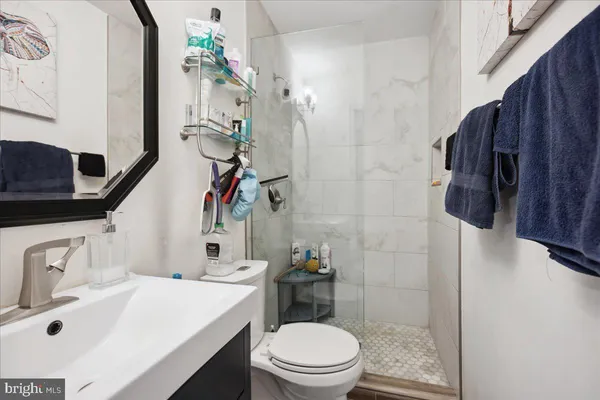 a bathroom with a sink a toilet and shower
