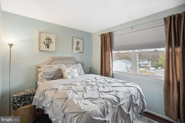 a bedroom with a bed and a large window