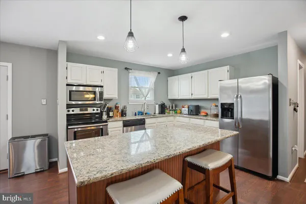 a kitchen with stainless steel appliances granite countertop a sink refrigerator and microwave
