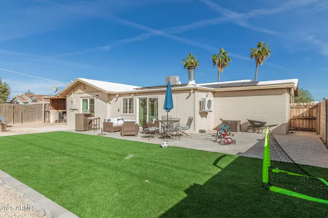 a view of a house with backyard sitting area and garden