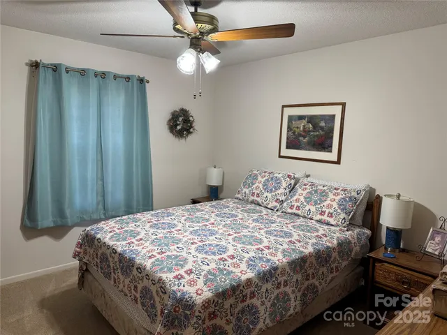 a bedroom with a bed and a painting on the wall