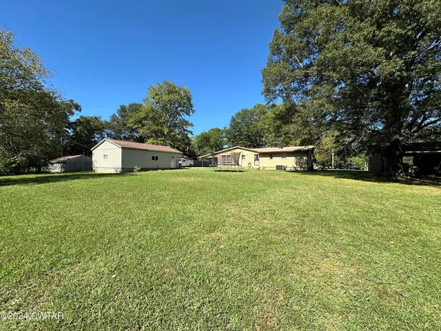 a view of a house with a yard and sitting area