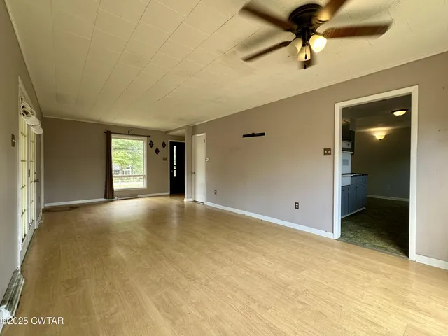 a view of an empty room and a ceiling fan
