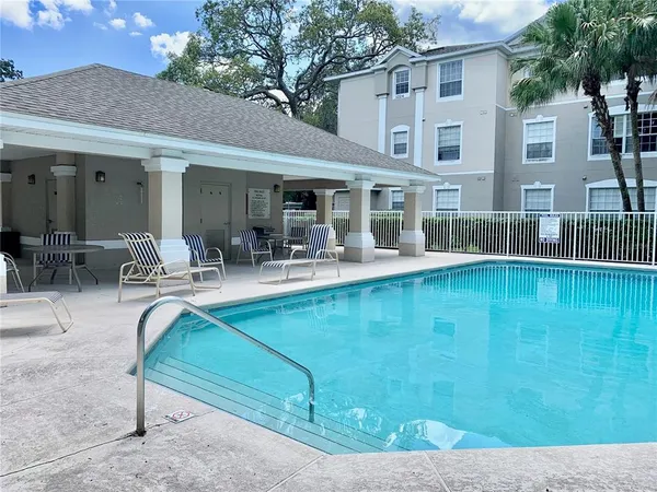 a view of a patio with couches chairs and swimming pool