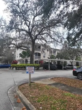 a front view of a house with a yard and large tree