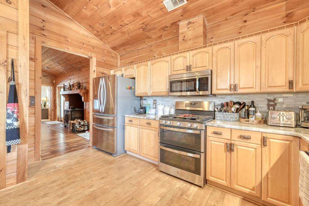 71 Andy Court Morganton, GA 30560 - Photo 11 of 43 a kitchen with stainless steel appliances granite countertop a stove a sink dishwasher and a refrigerator