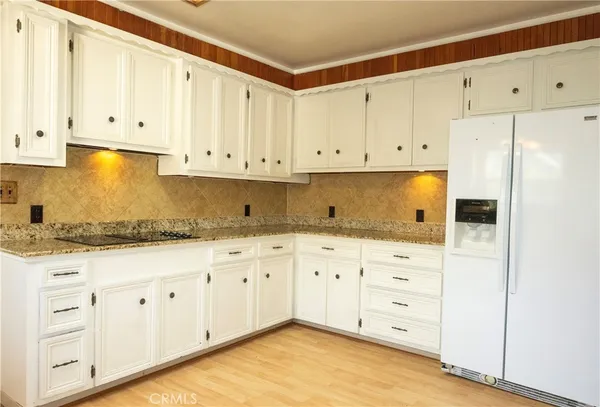 a kitchen with granite countertop white cabinets and stainless steel appliances