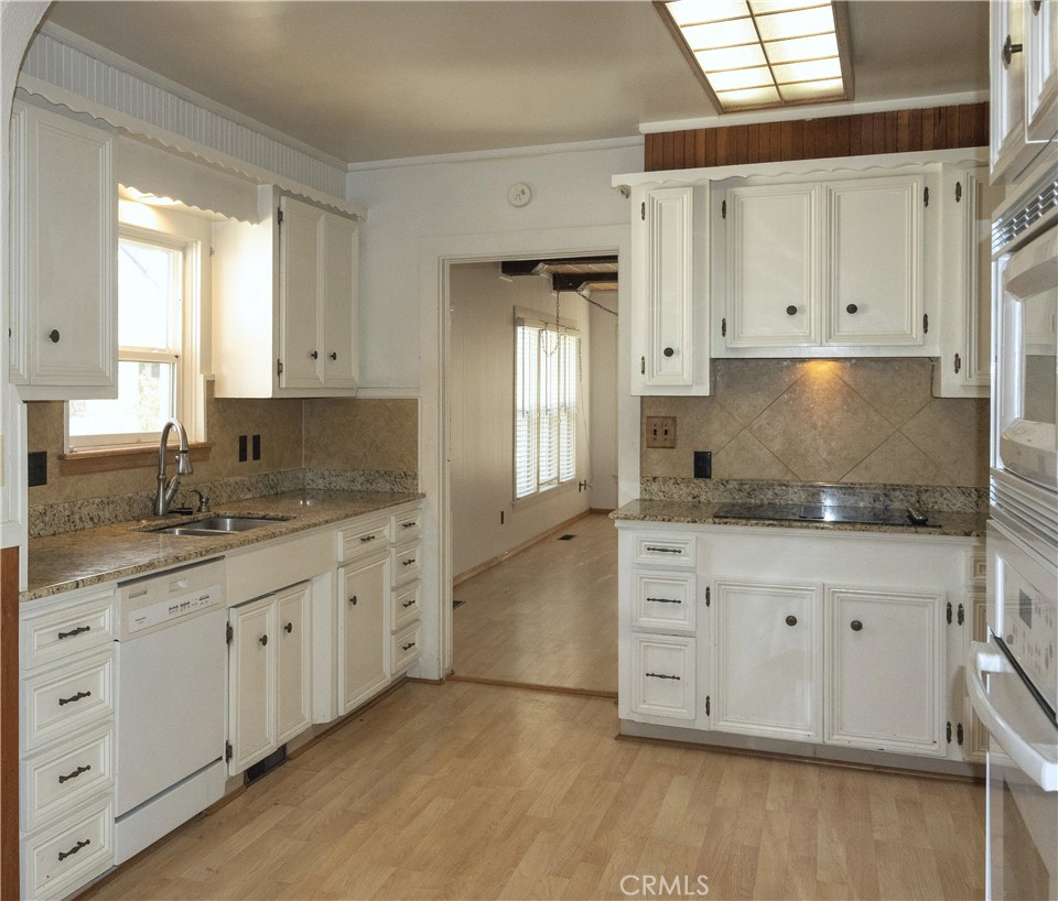 614 Lane Yreka, CA 96097 - Photo 9 of 39 a kitchen with granite countertop white cabinets sink and dishwasher with wooden floor