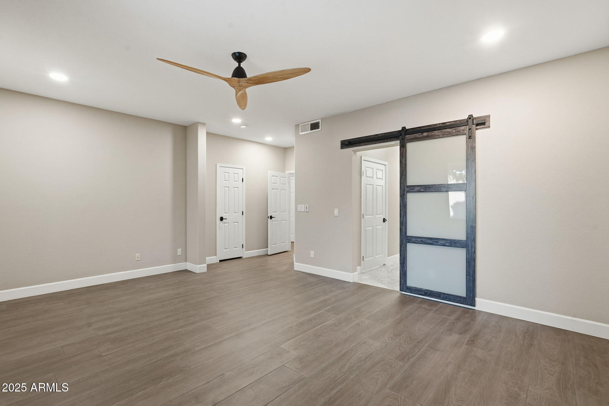 245 West Sagebrush Street Gilbert, AZ 85233 - Photo 24 of 62 a view of an empty room with wooden floor and a ceiling fan