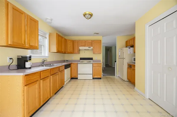a large kitchen with stainless steel appliances granite countertop a stove a sink and a refrigerator