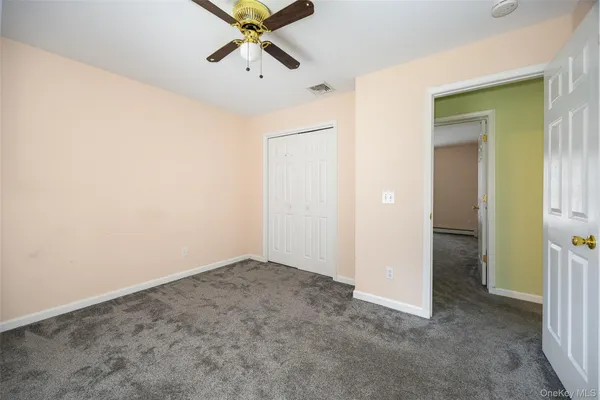 an empty room with closet and chandelier fan