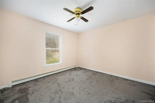 an empty room with a window and a ceiling fan