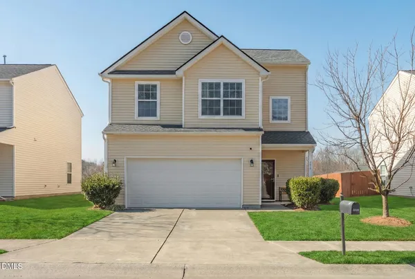 a front view of a house with a yard and garage